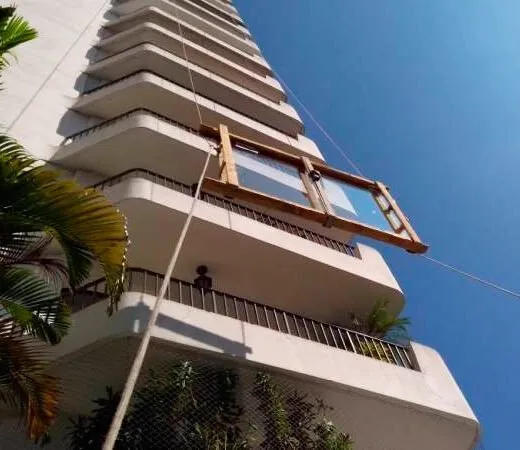 Janela de vidro sendo içada pela fachada de um prédio